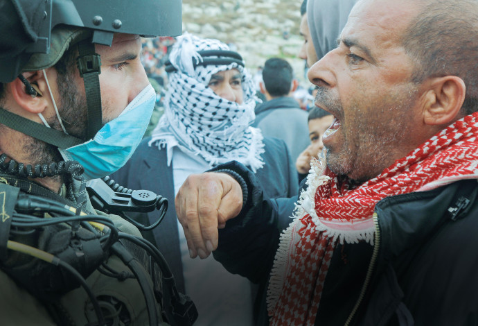 פלסטיני מול חייל צה"ל (צילום:  רויטרס)