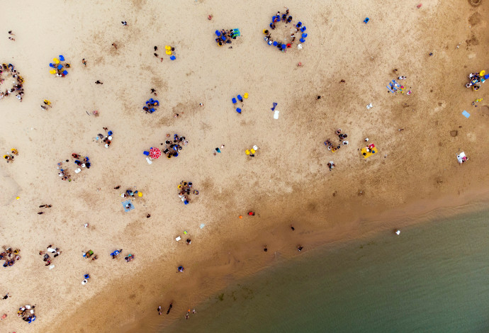 ישראלים בחוף הים בשרב (צילום:  REUTERS/Amir Cohen)