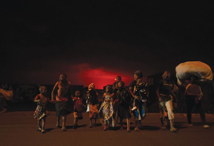 משפחה נמלטת מהעיר גומא הסמוכה להר הגעש שהתפרץ (צילום:  GUERCHOM NDEBO AFP VIA GETTY IMAGES)