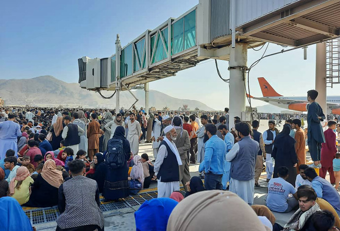 אזרחים אפגנים על המסלול בנמל התעופה בקאבול (צילום:  AFP via Getty Images)