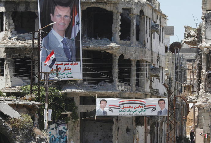 שלטים הנושאים את שמותו של נשיא סוריה בשאר אסד (צילום:  רויטרס)