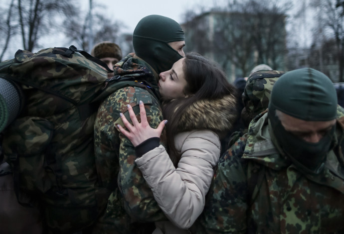 חייל אוקראיני נפרד מבת זוגו לפני שיוצא לקרב, למצולמים אין קשר לנאמר בכתבה (צילום:  רויטרס)