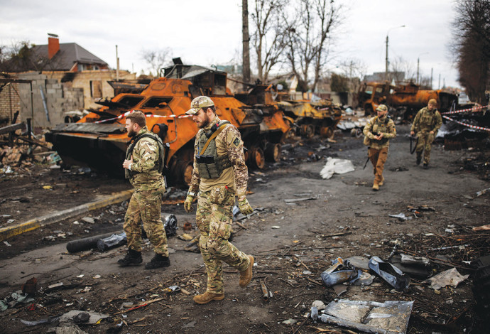 המלחמה באוקראינה, חיילים אוקראינים הולכים ליד טנק רוסי (צילום:  רויטרס)