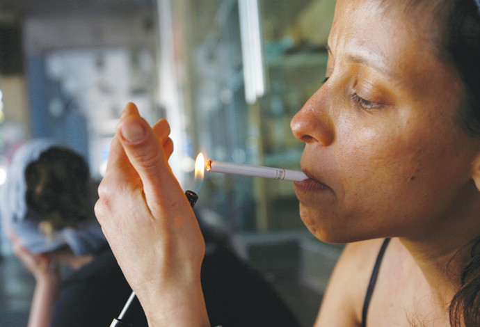 אישה מדליקה סיגריה בתל אביב - ארכיון  (צילום:  רויטרס)