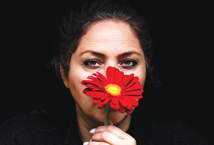 אישה עם פרח מתוך תערוכה העוסקת באלימות במשפח (צילום:  צופיה שלסקי)