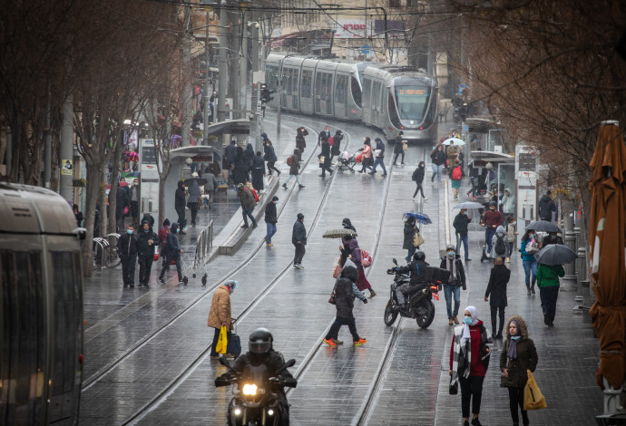 אנשים ברחוב בגשם בירושלים (צילום:  אוליביה פיטוסי, פלאש 90)