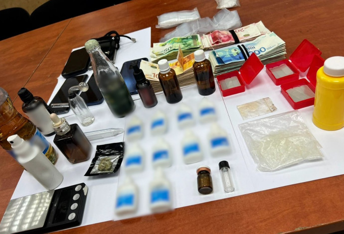 הבקבוקים עם חומר החשוד כסם אונס, הכסף והטלפונים שנמצאו בדירתו של החשוד בתל אביב (צילום:  דוברות המשטרה)