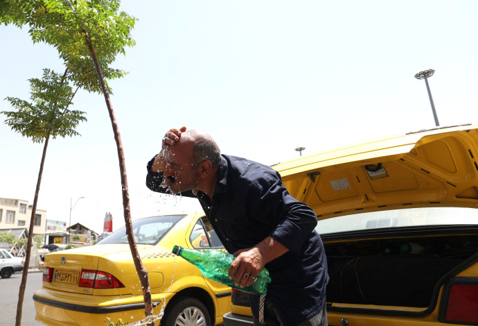 נהג מונית איראני מקרר את עצמו בעקבות החום הכבד (צילום:  Majid Asgaripour/WANA (West Asia News Agency) via REUTERS)