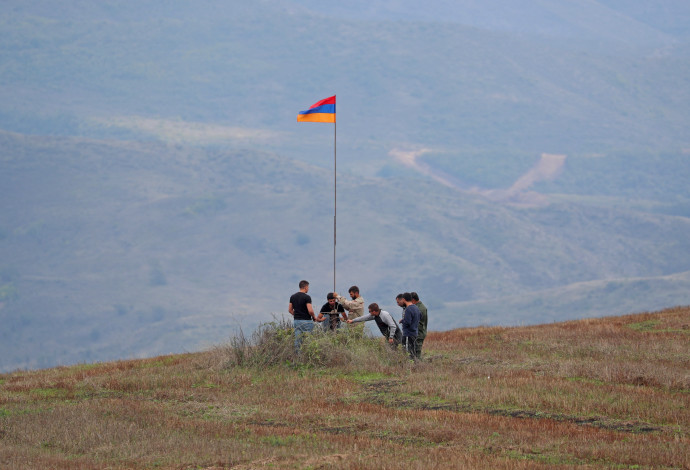 בדלנים ארמנים מניפים את דגל ארמניה בדרך המובילה למובלעת נגורנו־קרבאך (צילום:  רויטרס)
