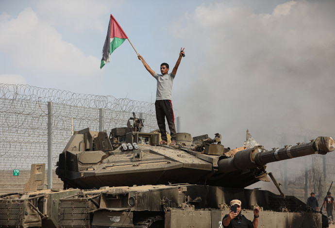 פלסטיני מניף דגל אש"ף מעל טנק ישראלי (צילום:  יוסוף מוחמד, פלאש 90)