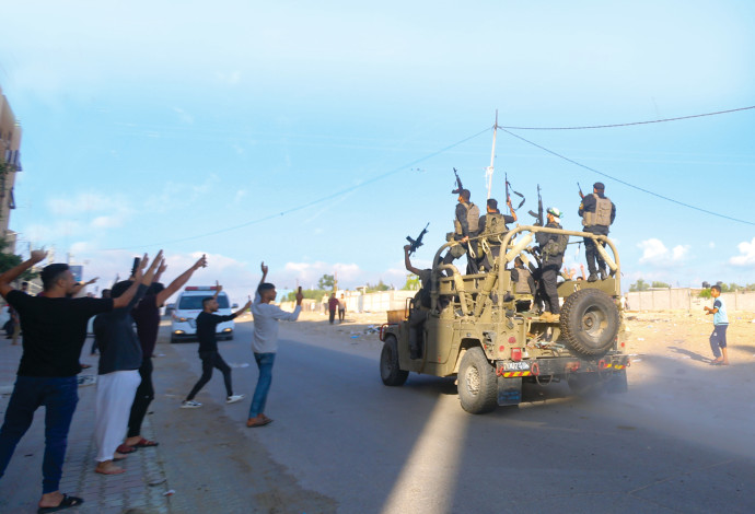 חמושי חמאס ופלסטינים מהרצועה חוגגים עם שלל של ג'יפ צה"לי, ב-7.10 (צילום:  עטיה מוחמד, פלאש 90)