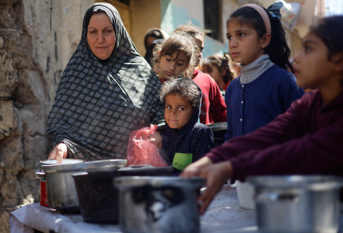 פלסטינים מחכים לקבלת מזון בעיר האוהלים ברפיח (צילום:  רויטרס)