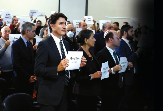ג'סטין טרודו, מרים שלט עם המשתתפים במהלך עצרת פרו-ישראלית באוטווה, קנדה, 9 באוקטובר 2023 (צילום:  רויטרס)