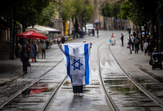 עם דגל ישראל בצפירה ביום הזיכרון לשואה ולגבורה בירושלים (צילום:  יונתן זינדל, פלאש 90)