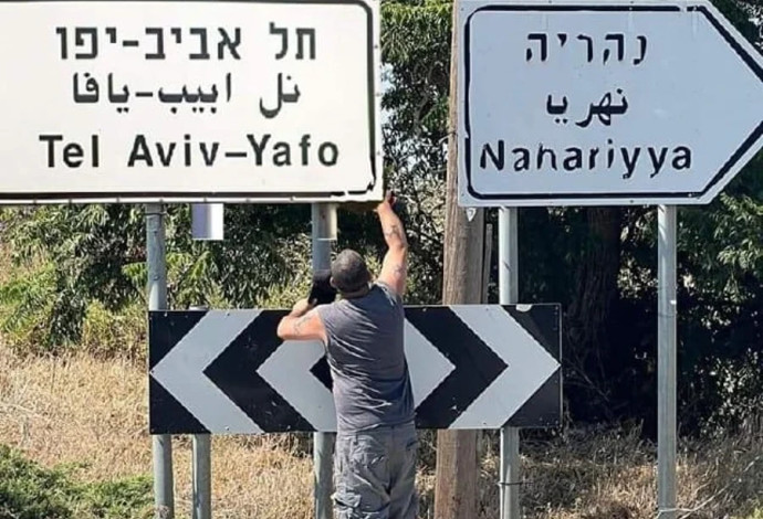 צחי אליהו מחליף את השלט של עין יעקב בשלט של העיר תל אביב (צילום:  רשתות חברתיות, שימוש לפי סעיף 27 א')
