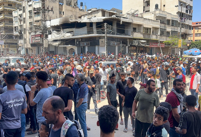 פלסטינים בעזה ממתינים לקבלת סיוע (צילום:  רויטרס)