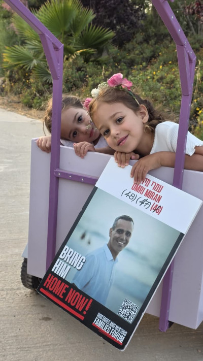 רוני ועלמא עם פוסטר של אבא עמרי מירן, יוני 2025