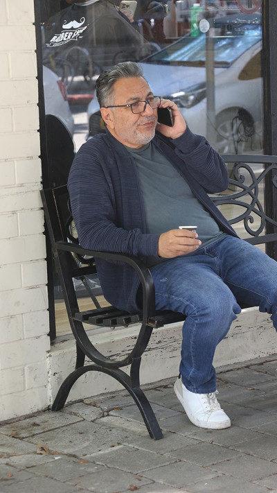 חיים כהן שותה קפה מחוץ למספרה  (צילום: פול סגל)