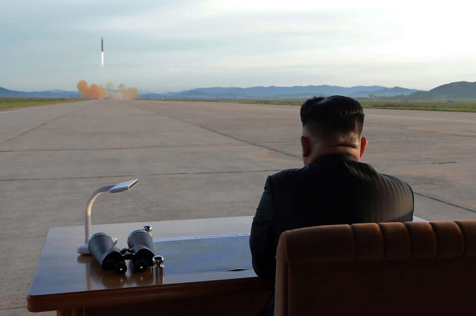 קים ג'ונג און צופה בשיגור טיל (צילום: AFP)
