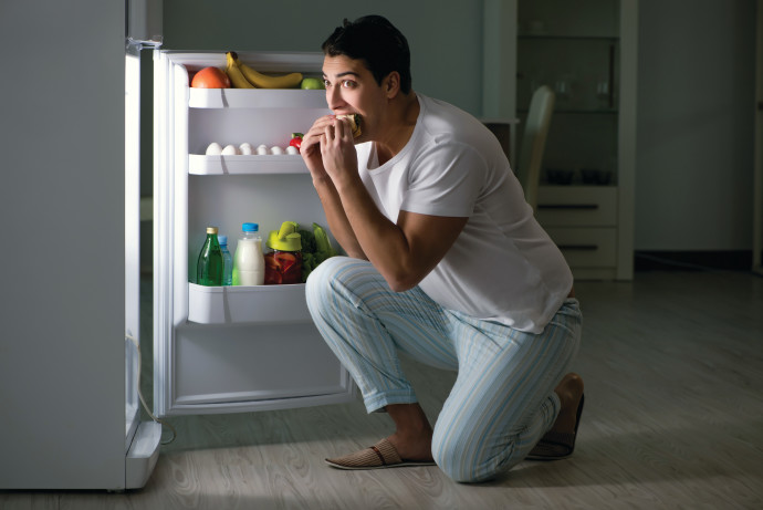 גבר אוכל מול המקרר בלילה, אילוסטרציה (צילום: אינג אימג')