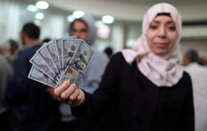 עובדת חמאס מציגה דולרים לאחר שקיבלה את משכורתה (צילום: רויטרס)