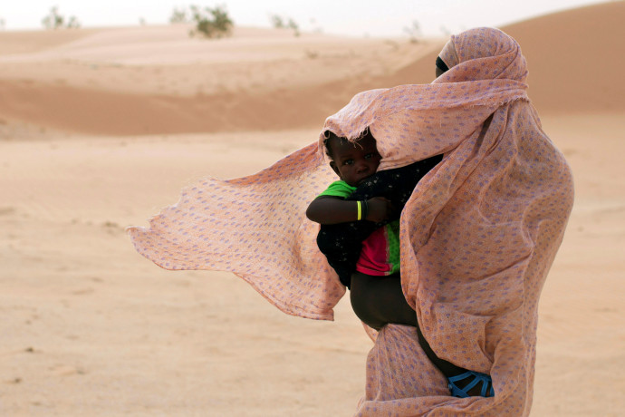 אישה מגנה על בנה מפני הרוח במאוריטניה, מערב אפריקה  (צילום: רויטרס)