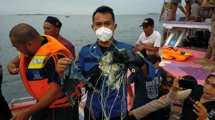 דייגים עם שרידי המטוס שהתרסק באינדונזיה (צילום: INSTAGRAM @HUMASJAKFIRE/via REUTERS)