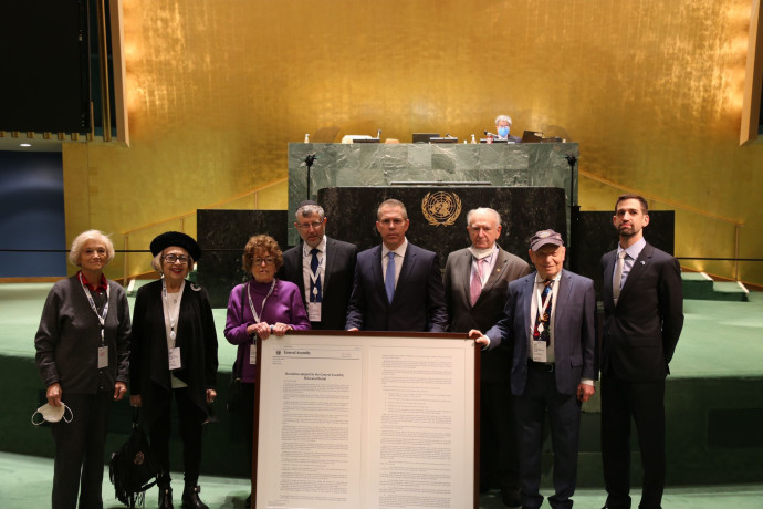 גלעד ארדן וניצולי השואה בעצרת האו"ם, עם ההחלטה שהועברה (צילום: ללא קרדיט)