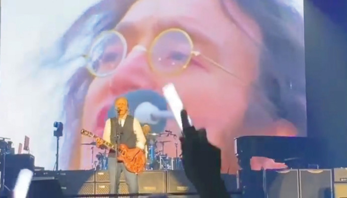 פול מקרטני בהופעה עם ג'ון לנון על המסך (צילום: צילום מסך)