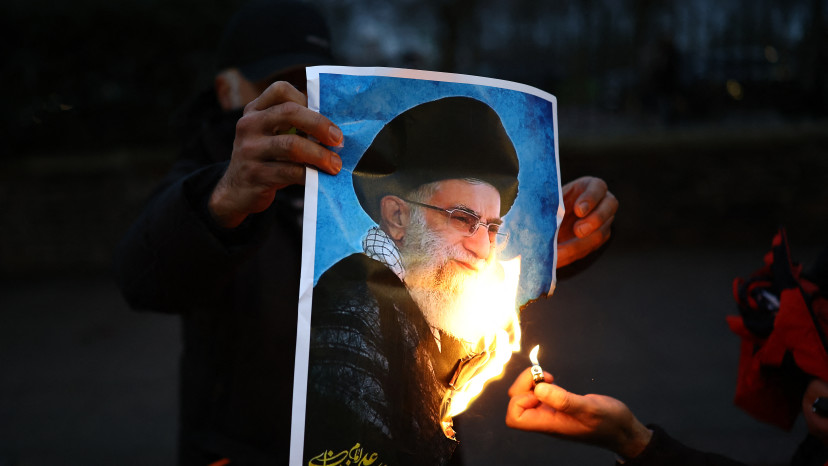 תמונתו של חמינאי עולה באש (צילום: HENRY NICHOLLS / AFP via Getty Images)