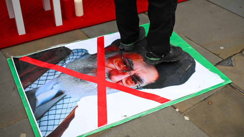 אדם דורך על תמונתו של מנהיג איראן, עלי חמינאי (צילום: GettyImages, Finnbarr Webster)