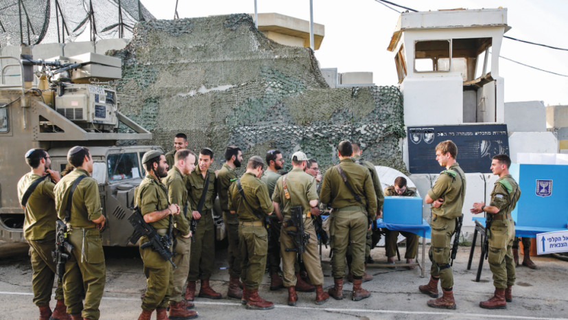 חיילים מצביעים בבסיס ליד גבול עזה (צילום: AFP)