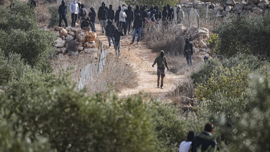 מתנחלים רעולי פנים תוקפים פלסטינים בעת מסיק הזיתים (צילום: פלאש 90)
