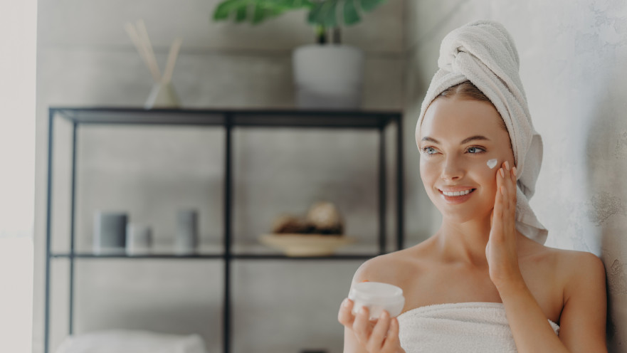 אישה מורחת קרם פנים