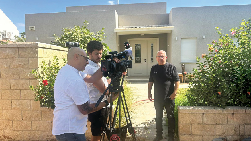 שמעון אלקבץ על רקע ביתו בכפר עזה