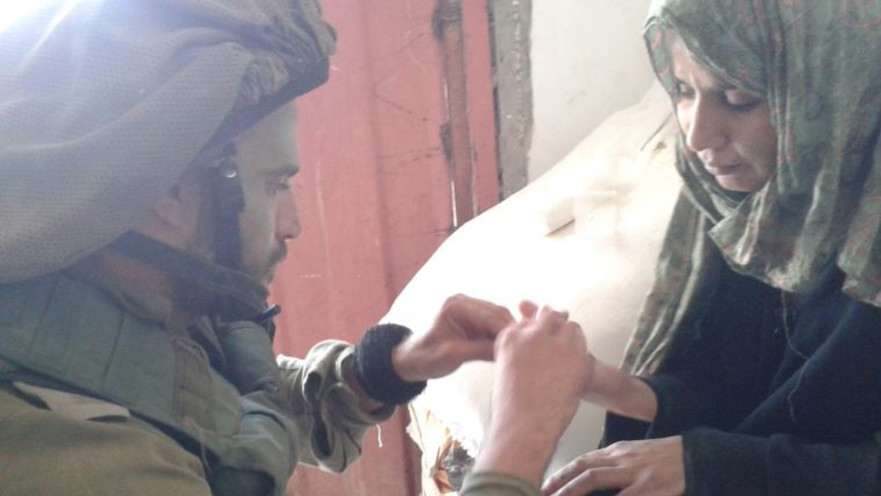 קצין אוכלוסיה במפגש עם תושבת עזה באזור לחימה במהלך צוק איתן