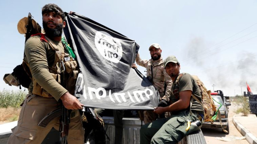לוחמים שיעים מציגים דגל דאעש שנתפס בלחימה בפלוג'ה