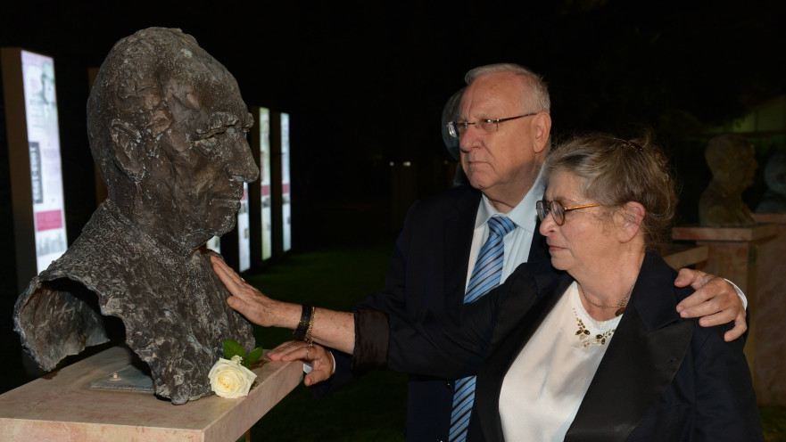 ראובן ונחמה ריבלין מניחים פרח על פסלו של שמעון פרס