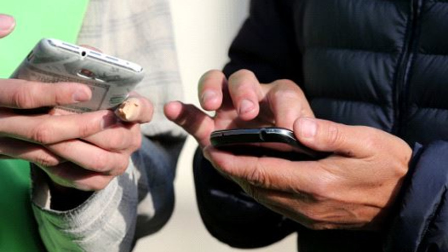 אנשים מחזיקים טלפונים סלולריים