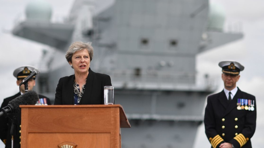 תרזה מיי על רקע נושאת המטוסים "המלכה אליזבת"