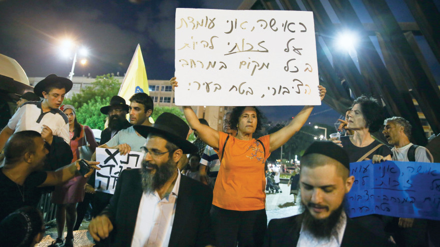 אישה מפגינה ליד אירוע "משיח בכיכר"