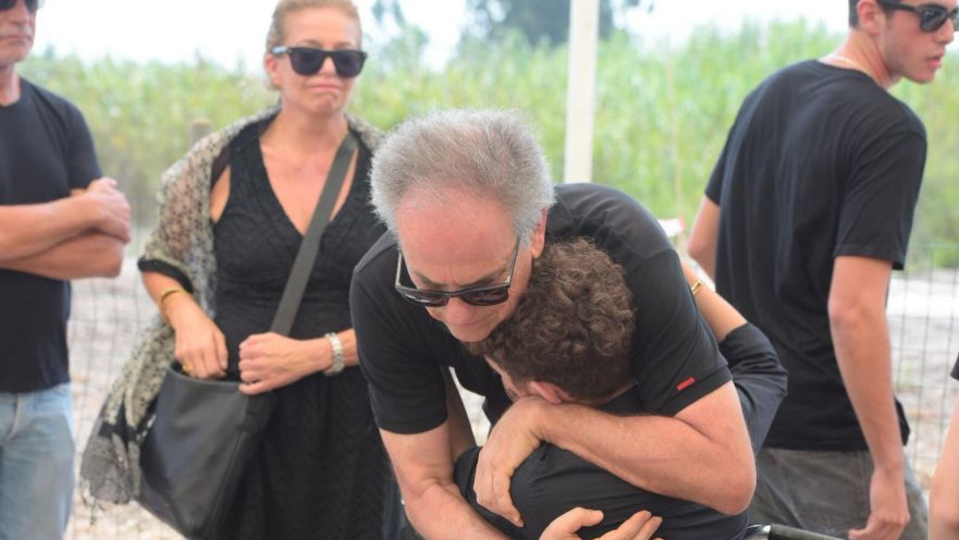 אבי נשר מחבק את הנער שהרכיב את ארי על האופניים