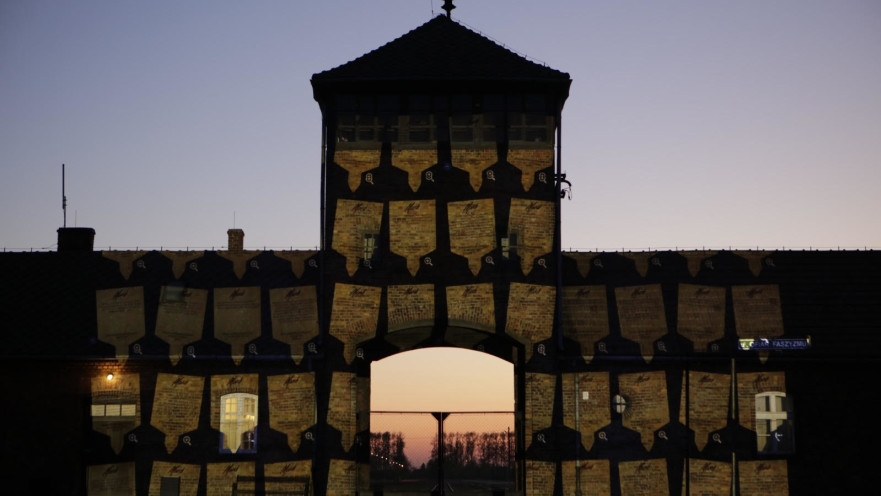 השלטים המוקרנים על שער מחנה ההשמדה בירקנאו