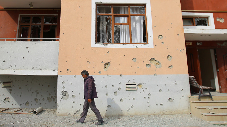 גבר הולך בהריסות בניין מגורים באזרבייג'ן