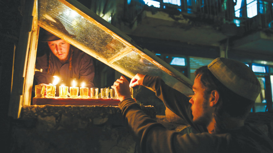 ילד מדליק חנוכייה 