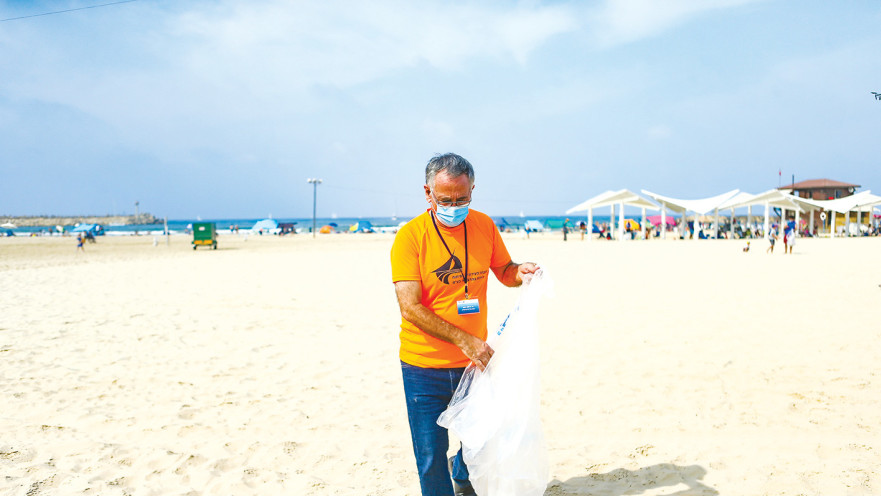 ראש עיריית הרצליה, משה פדלון, באיסוף פסולת פלסטיק בחופי העיר