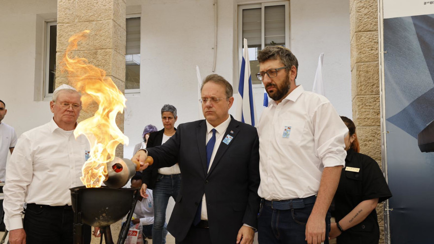 אדוארד גרמן (מימין) וגרמן רוז׳קוב (משמאל) שחולצו לאחרונה מאוקראינה בסיוע הסוכנות היהודית, מדליקים את לפיד הזיכרון יחד עם יעקב חגואל. 