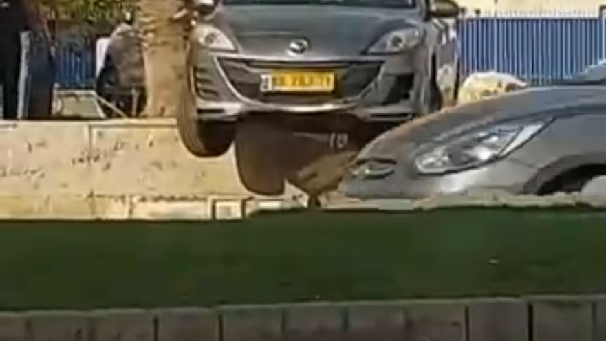 הרכב שנותר תלוי על החומה. עוברי אורח מיהרו לתעד את האירוע הנדיר