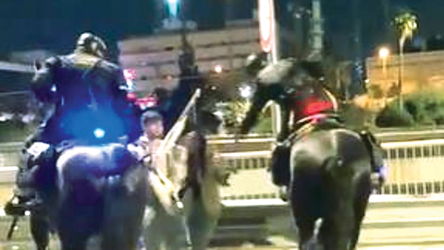 שוטר מכה מפגינה