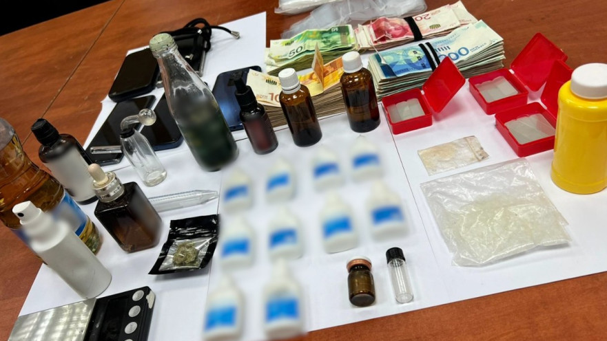 הבקבוקים עם חומר החשוד כסם אונס, הכסף והטלפונים שנמצאו בדירתו של החשוד בתל אביב